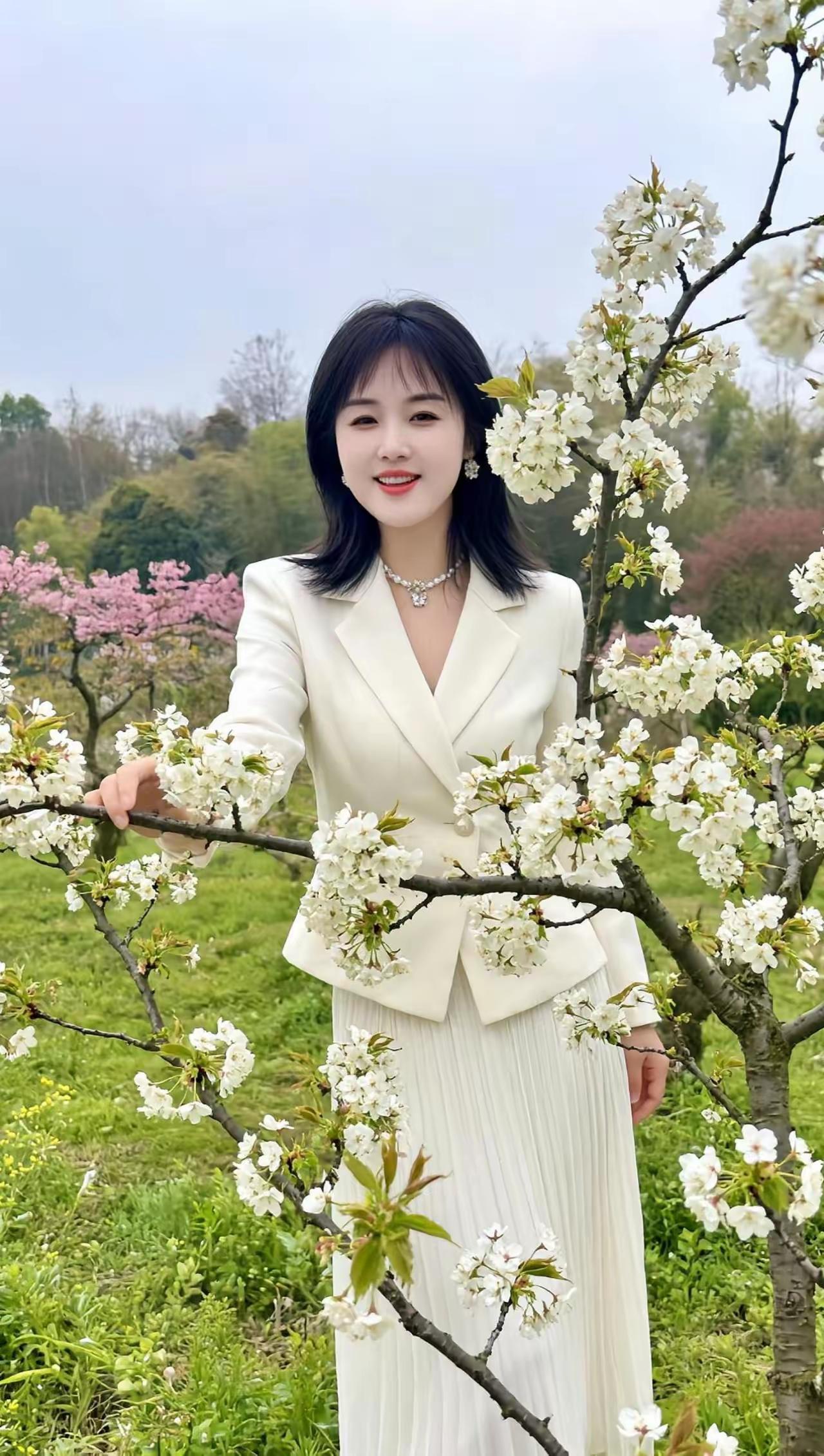 春日花海中的优雅穿搭，白色西装与粉色樱花相映成趣。