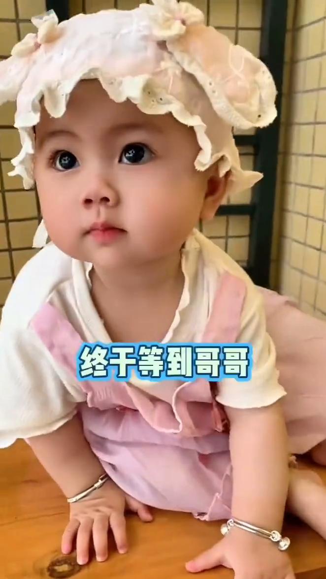 一脸期待。傍晚时分刚睡醒的女儿正等候即将放学的哥哥，终于等到哥哥。