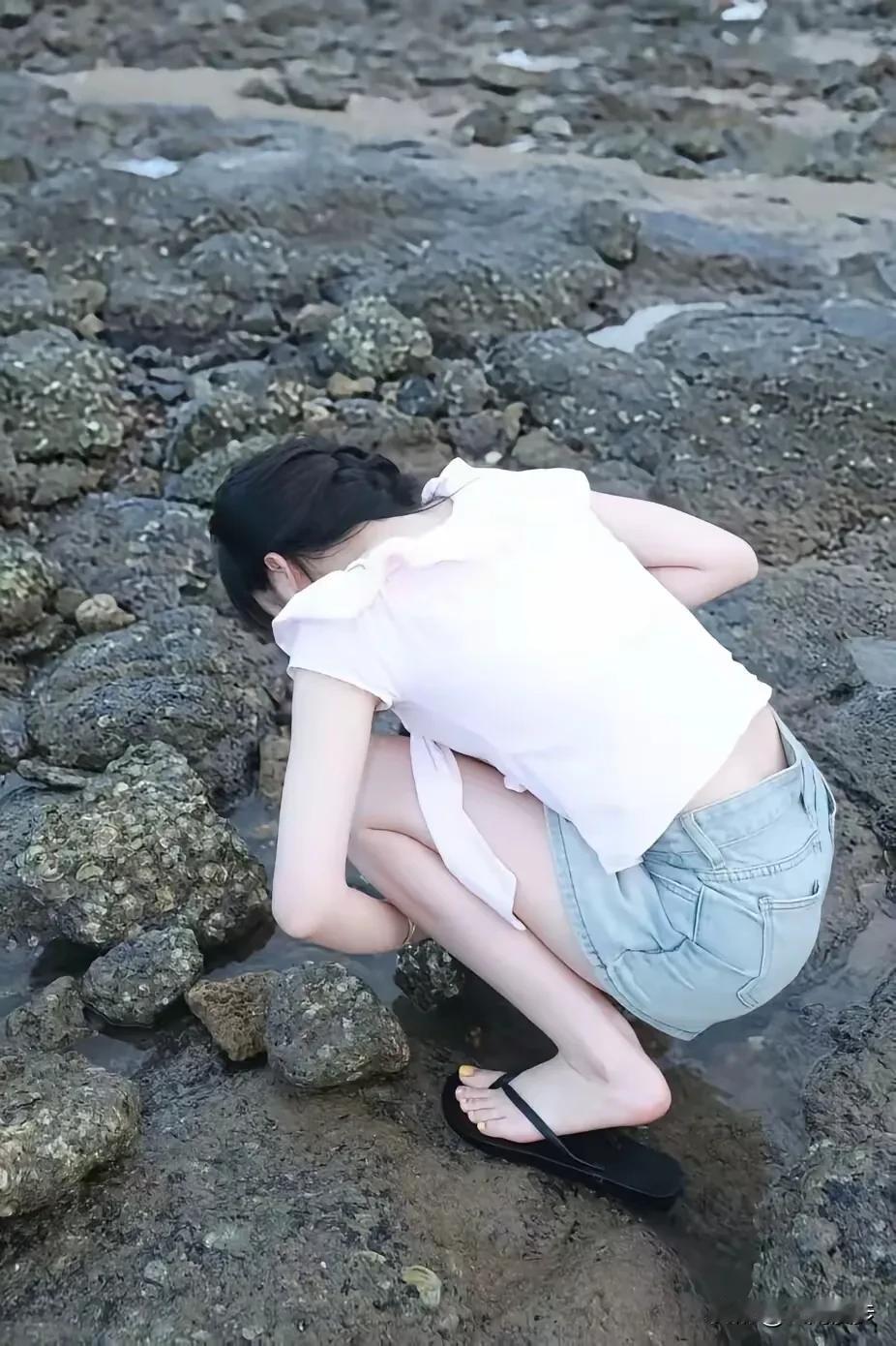 家人们谁懂呀！这位女孩身姿轻盈灵活，在礁石的缝隙之间捉蟹子，已然奋战了两个小时。