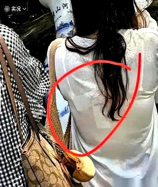 就那张火了的抓拍图，一个穿白T恤的姑娘，背影简简单单。唯独后背正中间贴着一块白色