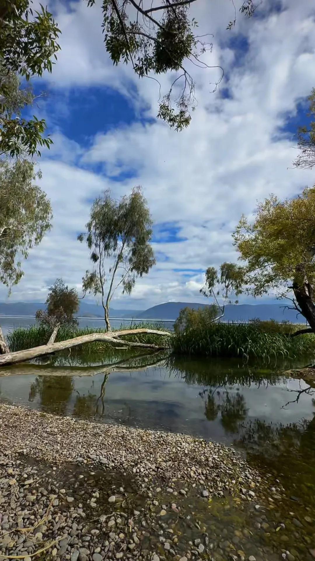 天山湖畔，湛蓝的湖水宛如宝石镶嵌在大地，倒映着洁白的雪峰和湛蓝的天空。