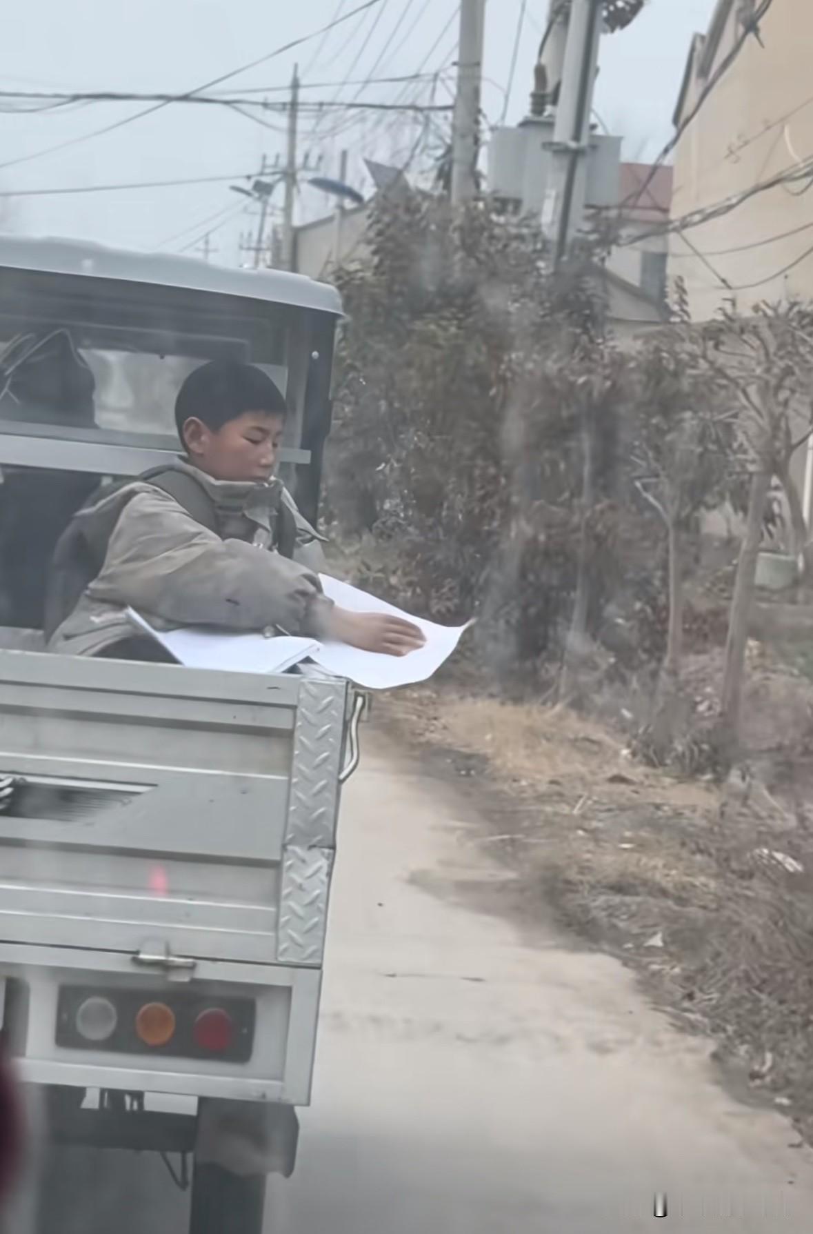 太搞笑了，这个小孩哥为了寒假不写作业，坐在电三轮上扔卷子扔了一路。
后面的车辆直