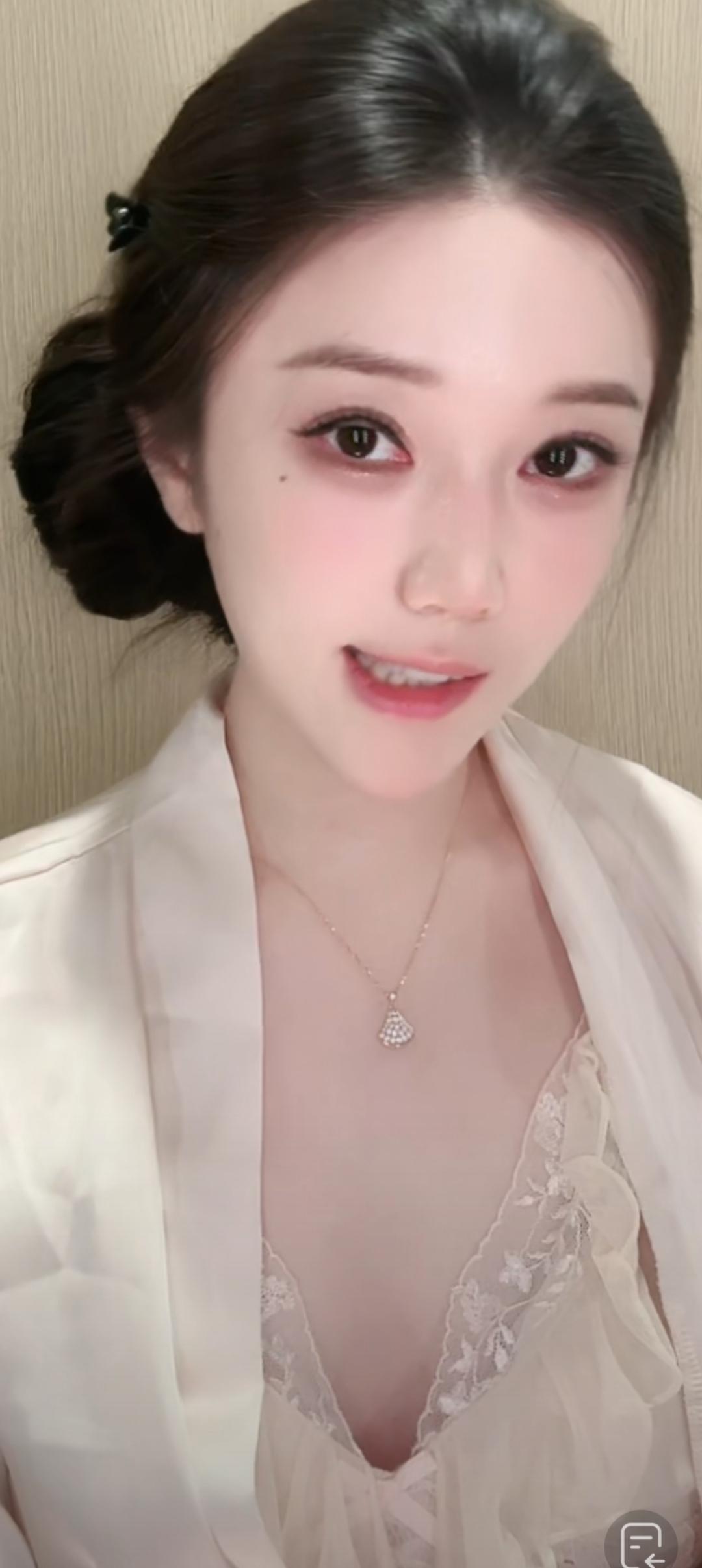 这位美女穿着睡衣，看着镜头微笑。