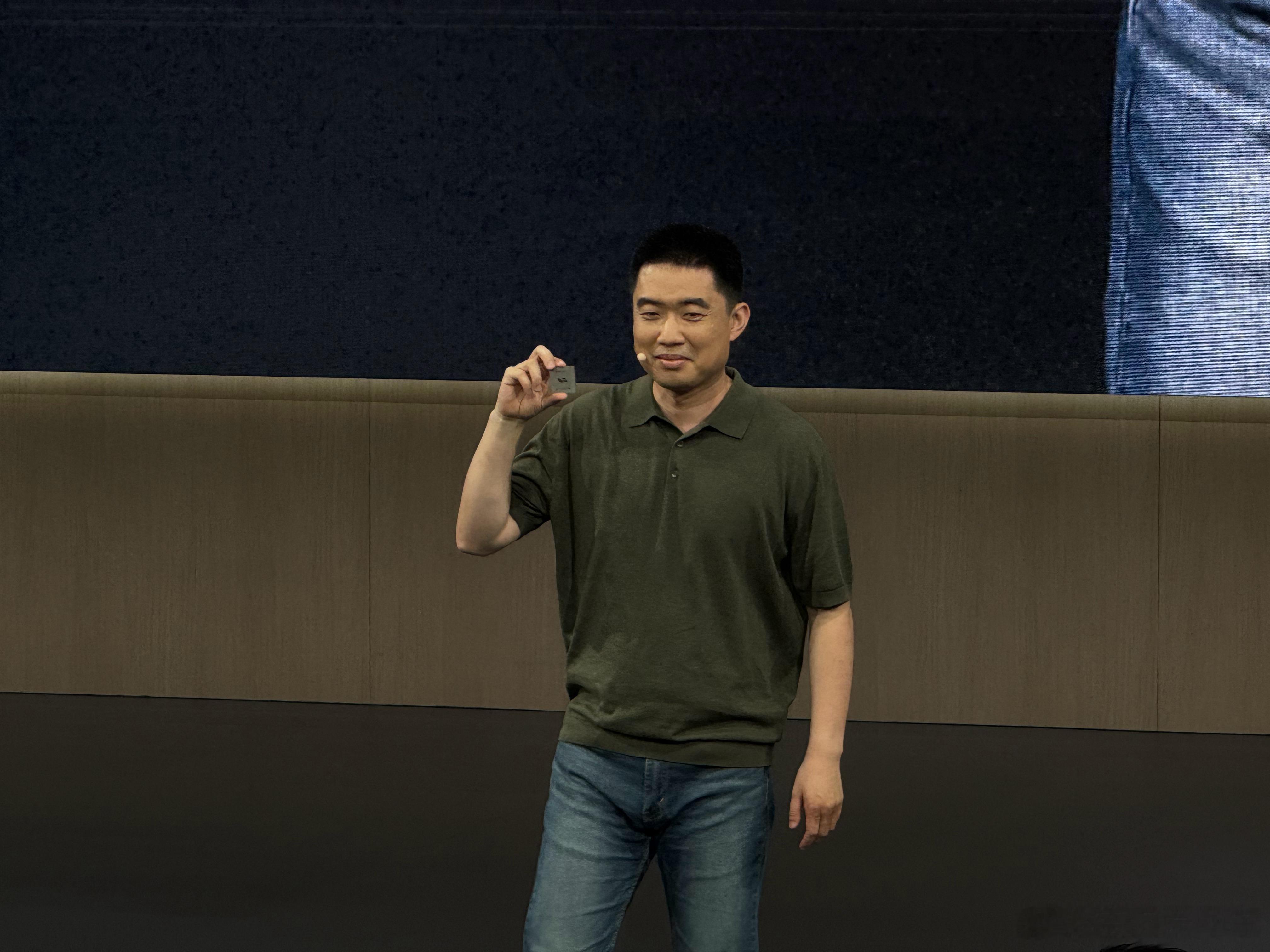李想：给我拍一张，不然网上都是我掀桌子的图片。李想手里的是 全球首颗数据流架构的
