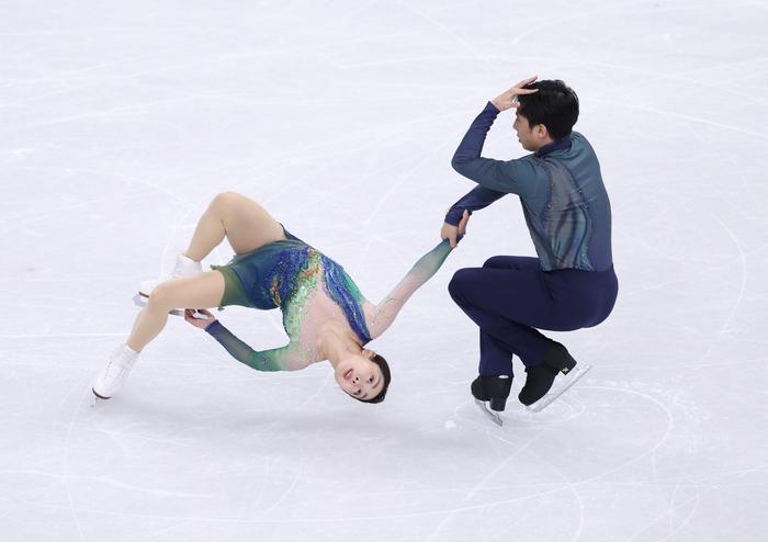 冰面如宣纸在灯光下铺开，幽幽青绿从脚尖蔓延开去，隋文静和韩聪的身影在冰上牵连成画