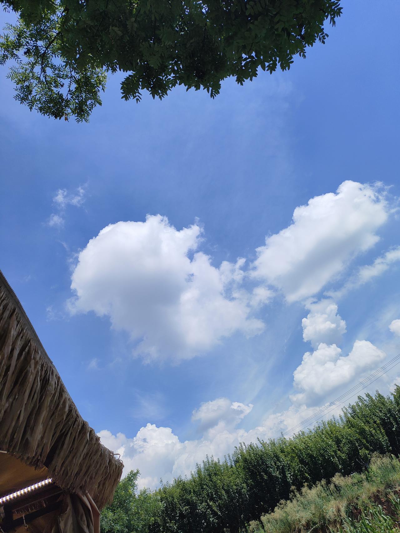 ​2. 茅草檐下望云天，清风伴白云，尽享夏日的一份悠然。