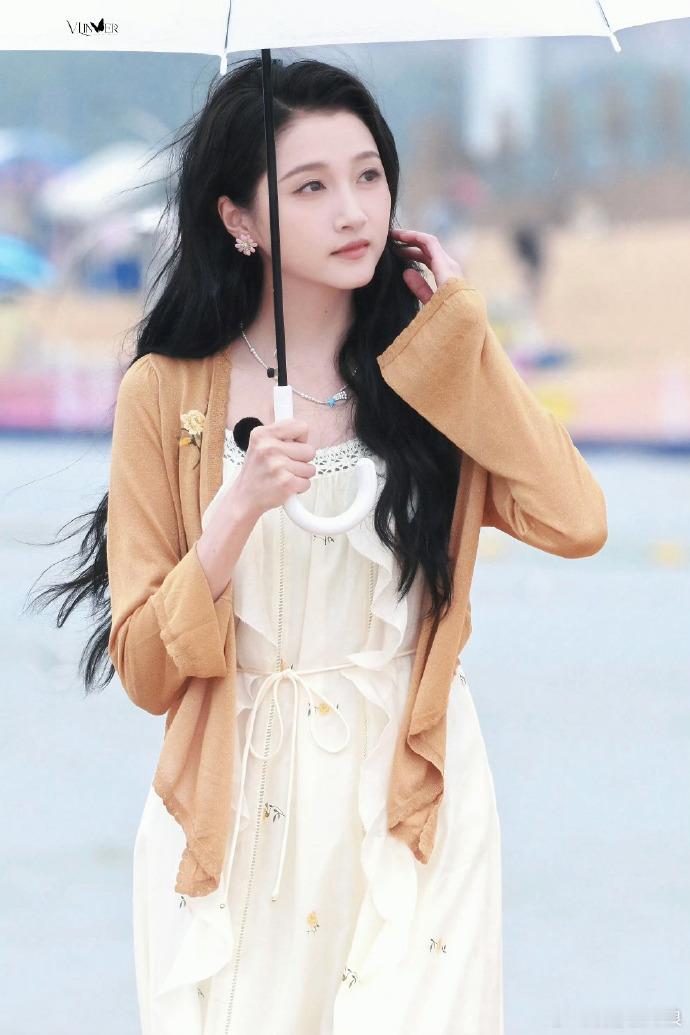 关晓彤梦回晴格格海边微风拂动裙摆，关晓彤撑伞静立模样清雅恬静，眉眼间柔和大方的气