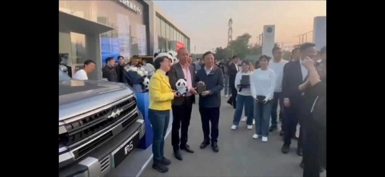 王传福亲自为豹5车主交车， 和车主合影的时候，王总让方程豹汽车销售总经理熊总站到