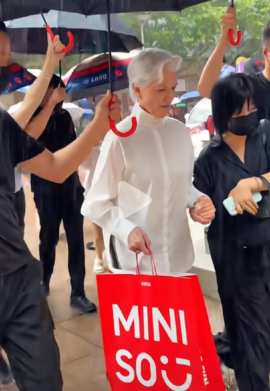 首富马斯克的妈妈出现在上海南京路上，周围一堆保镖和助理，撑伞的撑伞，开车门的开车