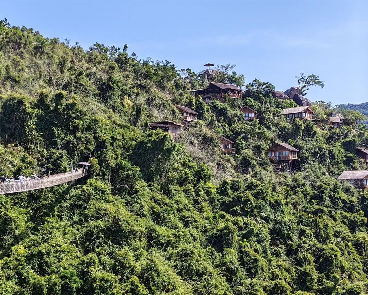 木屋嵌进绿浪里，像被森林悄悄藏起的梦，连栈道都在说：“来，去触摸，山野的心跳。”