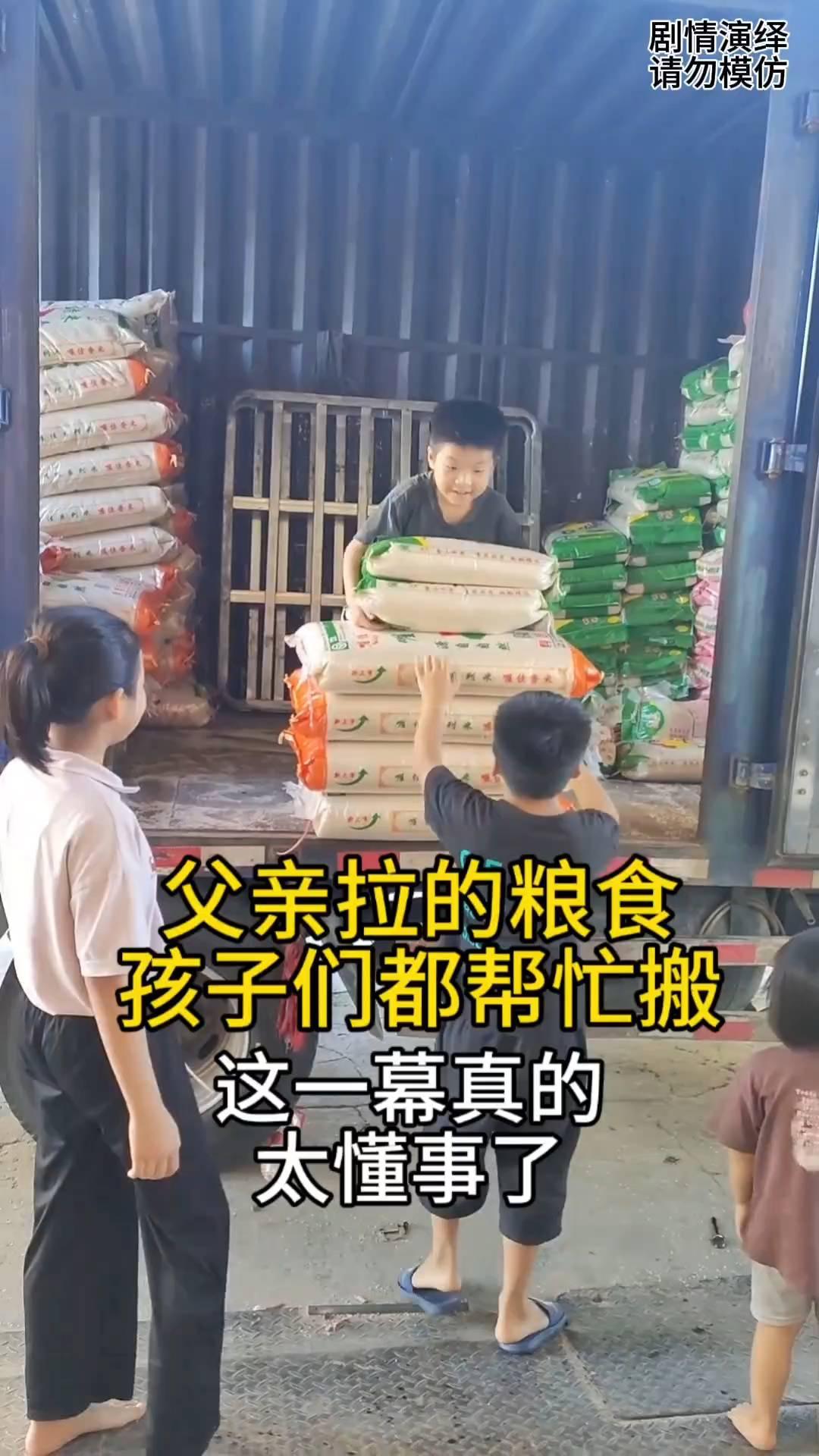父亲拉了一车粮食在忙活，谁知家里小孩放学后都去帮父母，只见他们有搬粮食的，还有在