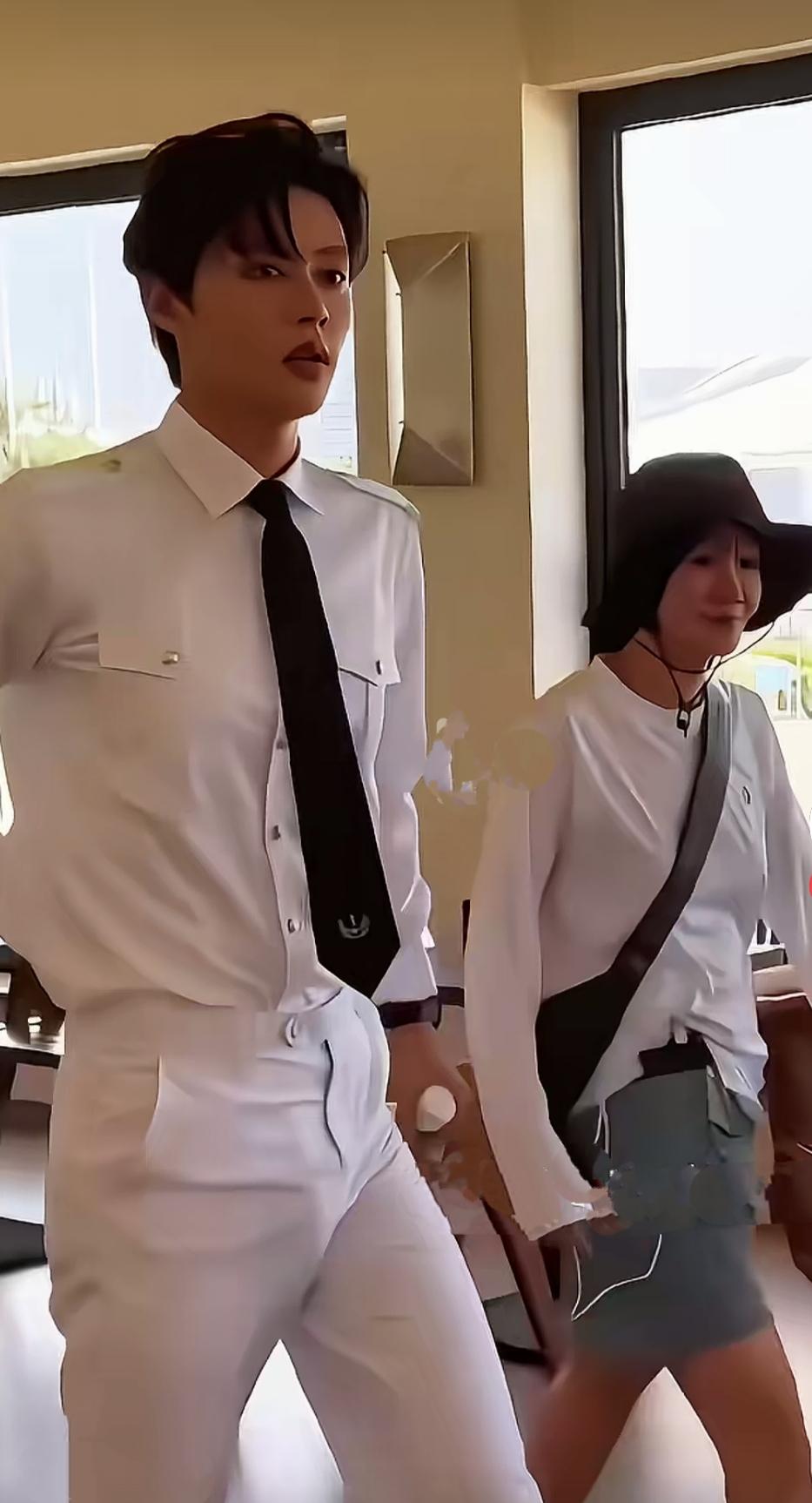 杜淳一身笔挺的白色制服，修身版型勾勒出 他挺拔的身型，步伐透露出他的自信从容，这