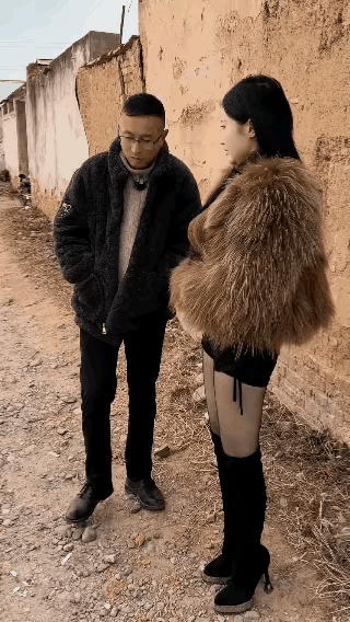 一个美女站在街头，穿着很时髦也很时尚，还时不时的跟经过的男人搭话，这样的场景还真