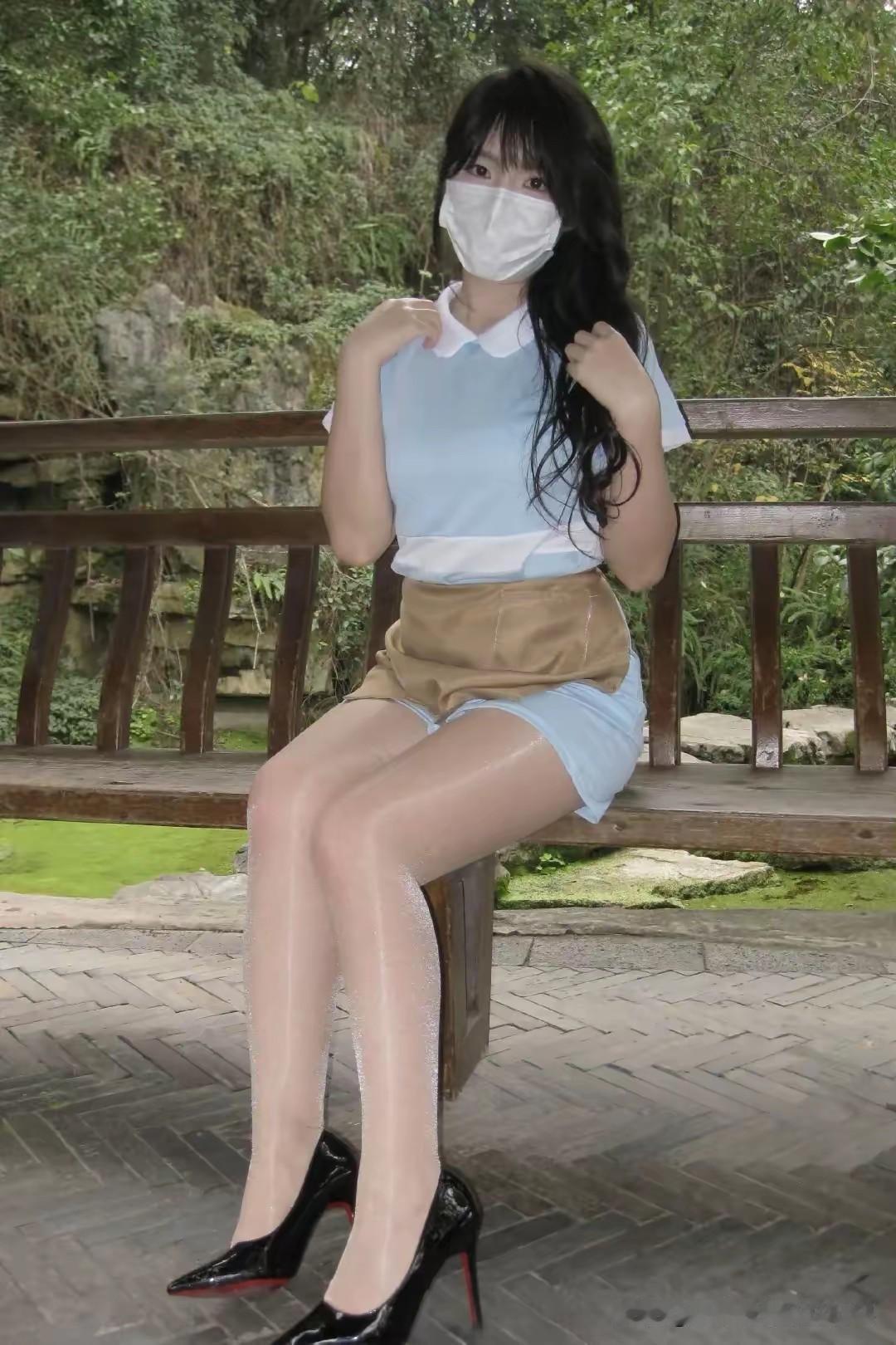 绿树掩映中，红妆美人倚长凳。