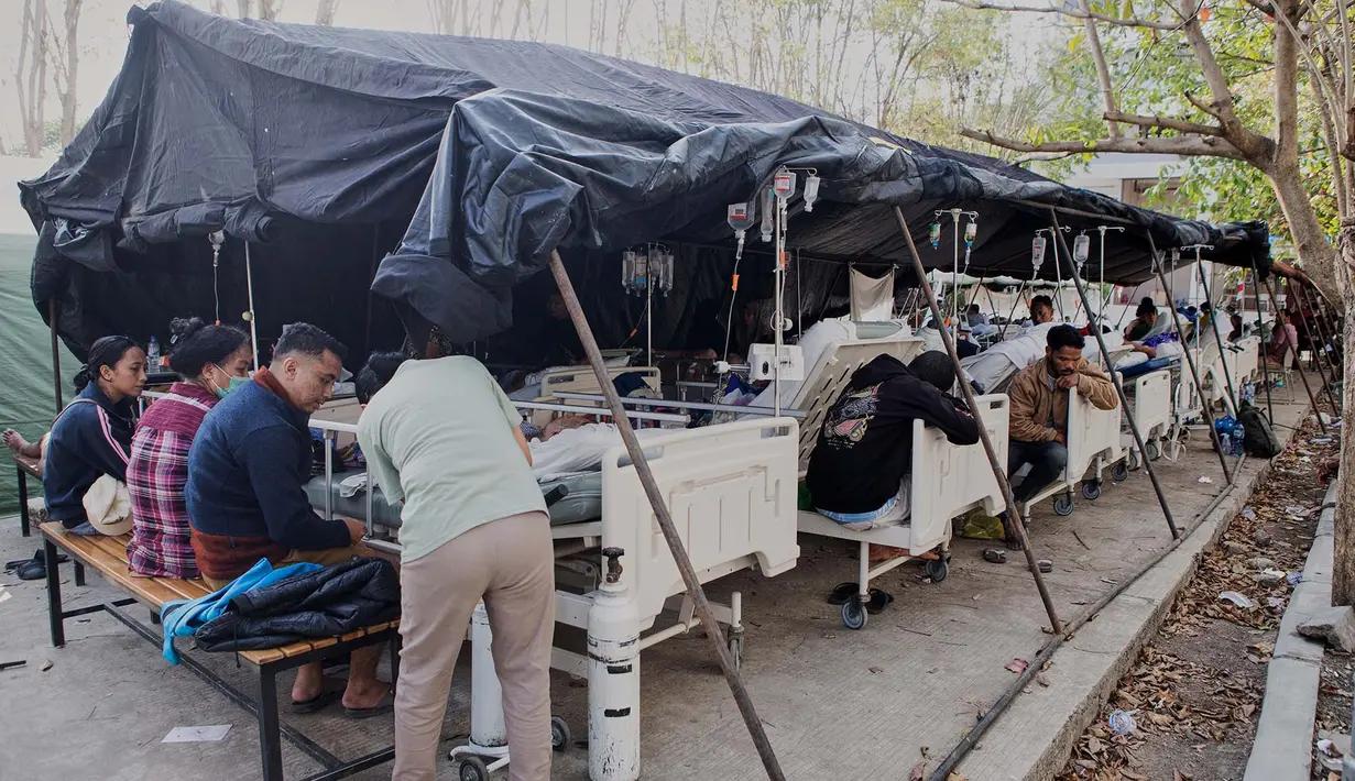 印尼医务人员正在救助地震中的伤者，医院内部场地有限，只好在外面搭建临时帐篷。