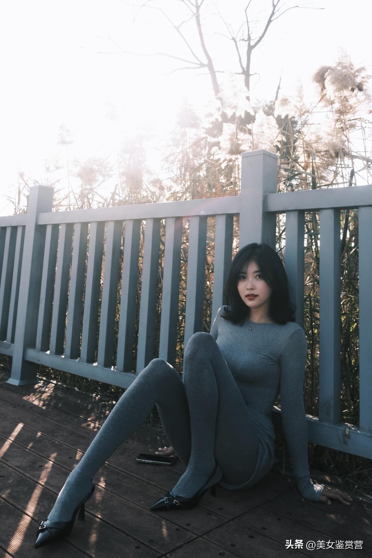 秋日午后的阳光，像被揉碎的金箔，落在灰蓝色的木栈道上，温柔得让人想融化。

一袭