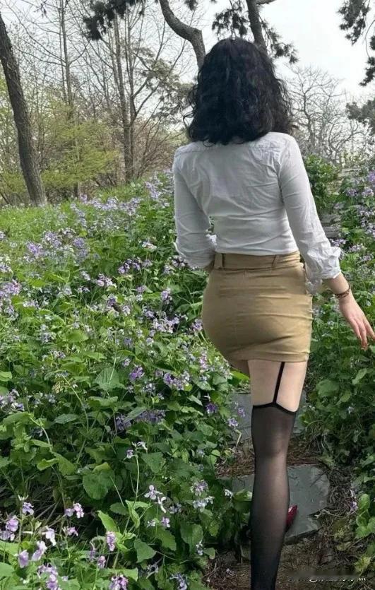 在繁花似锦、芬芳满径的花园里，有位女士引人注目。她身形优美，举止优雅，一颦一笑魅