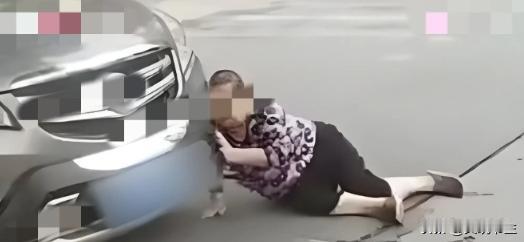 “干的漂亮！”辽宁沈阳，一大妈在街上闲逛，看到路上停了辆豪车，她往车灯上一蹭，又