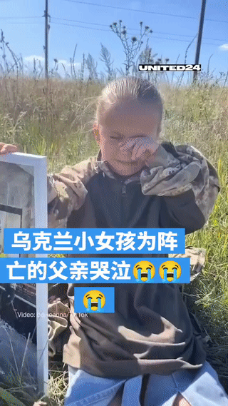 一名乌克兰小女孩用手扶着已故爸爸的遗像伤心的哭泣，看起来真是太让人心疼了！😭