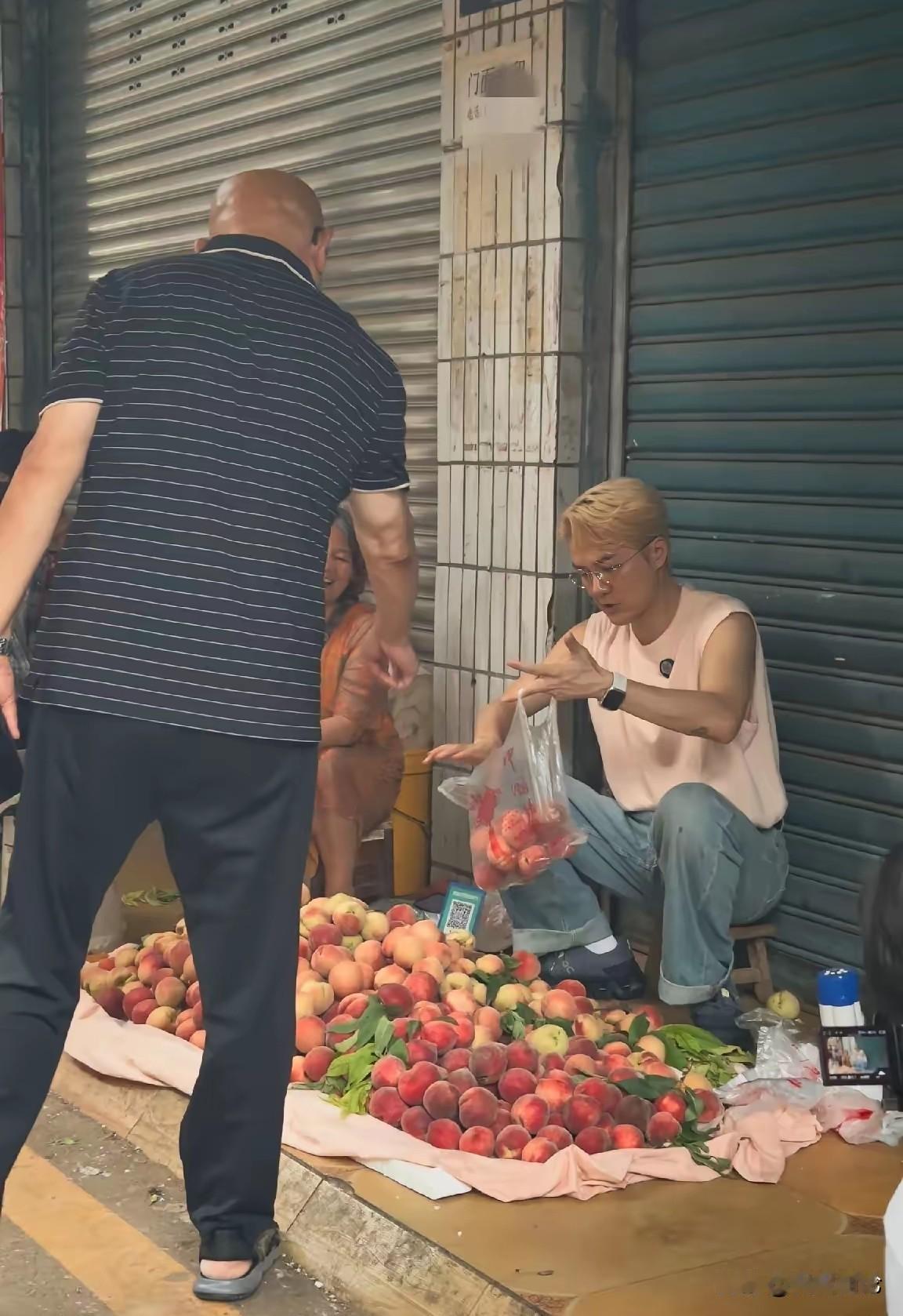 看着怎么这么面熟，这不是吴克群吗，在街头卖桃呢，原来这是为他的家乡遂宁做的助农活