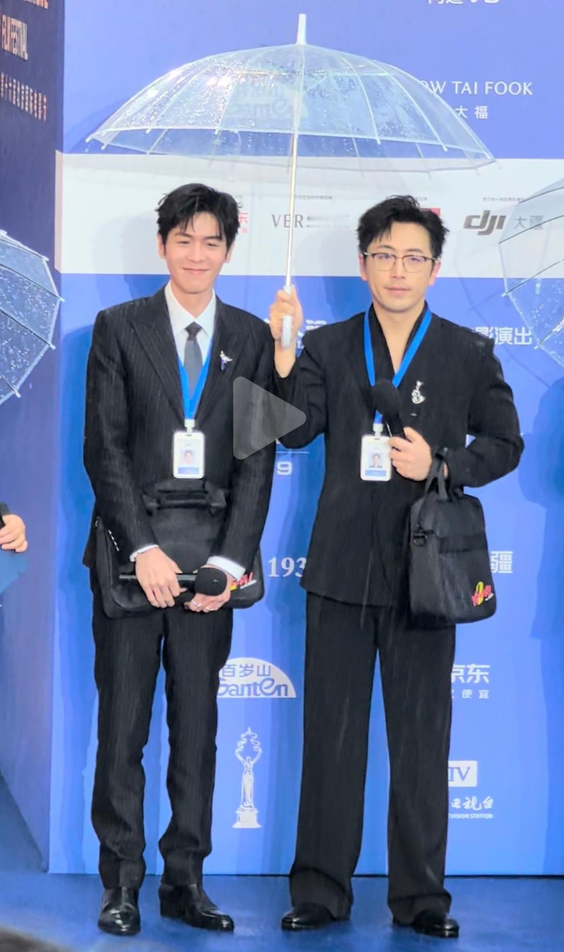 笑出声，《年会不能停2》走红毯，叽里呱啦的雨水中白客撑伞而来。雨天、西装、撑伞，