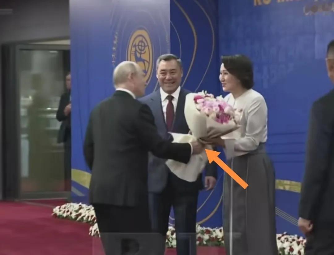 普京向吉尔吉斯坦总统夫人献上一捧鲜花。