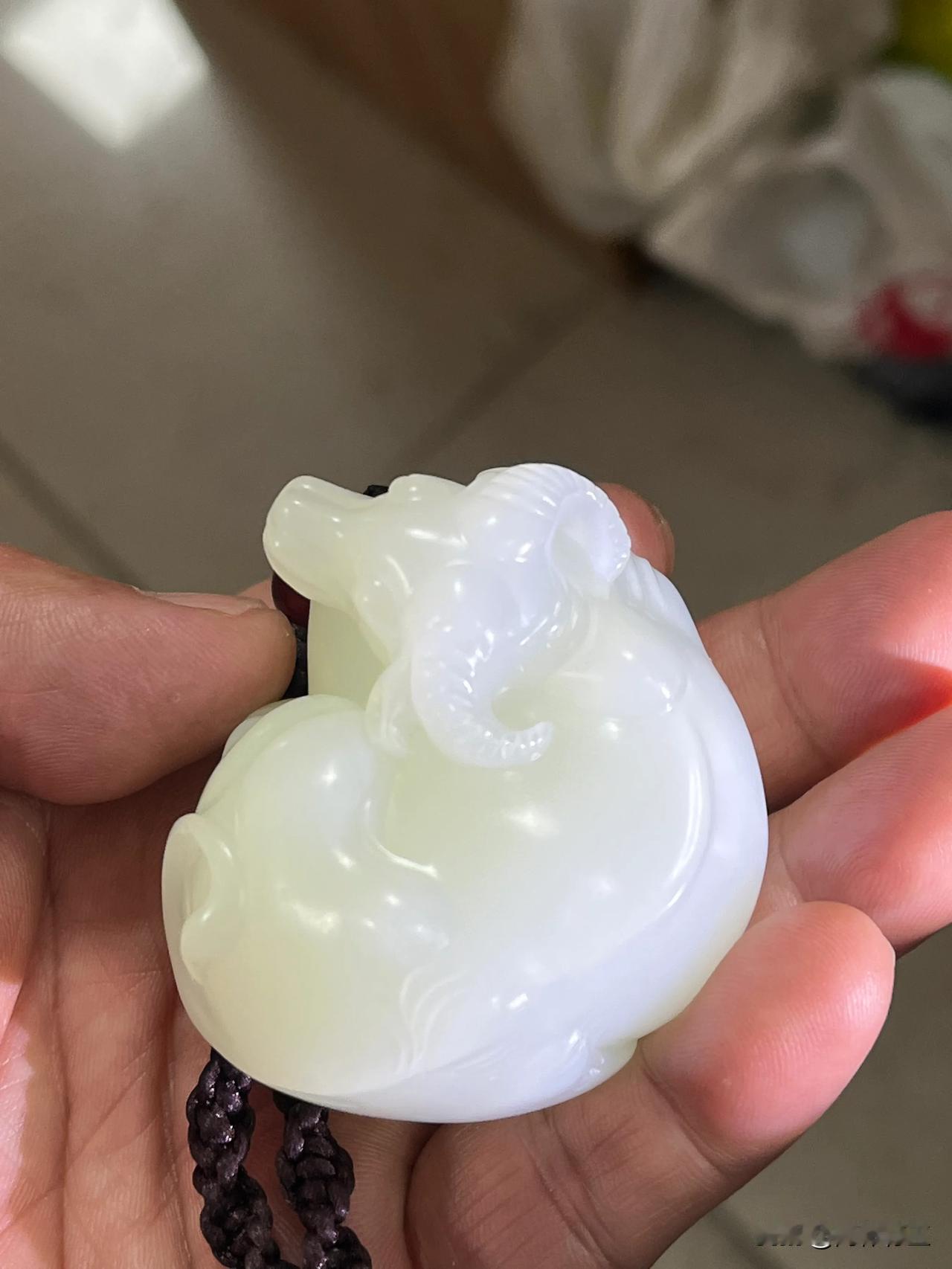 这是一款和田玉牛手把件，温润洁白的玉质，细腻光泽。匠师精心雕琢，牛的形态栩栩如生