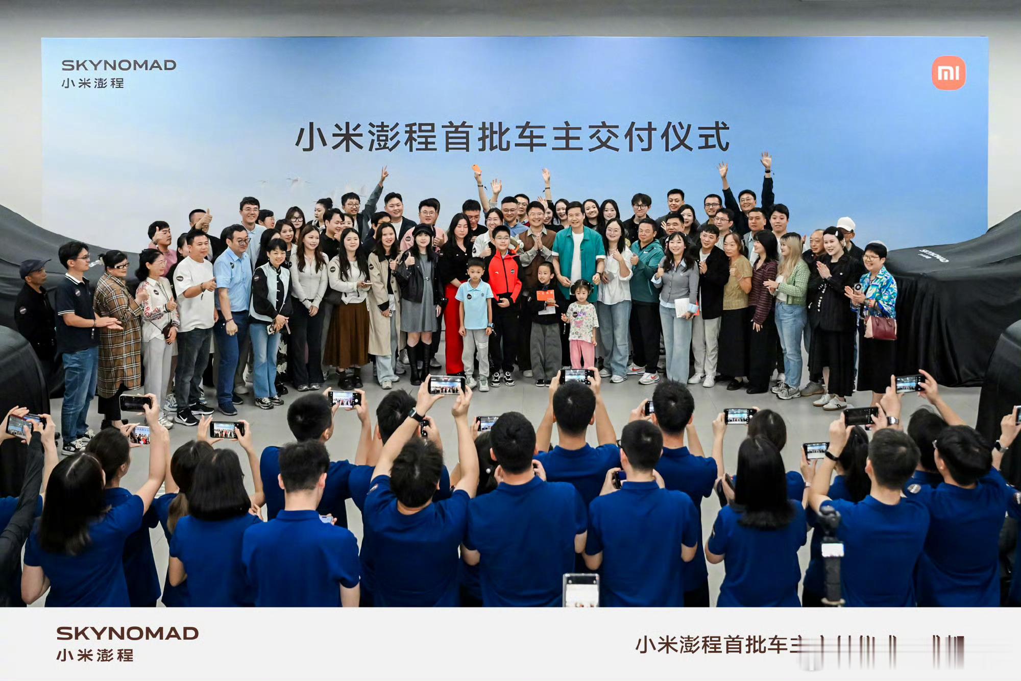 澎程车主拿初代小米手机与雷军合影刷到交车现场，车主捧着早年的初代小米手机和雷军合