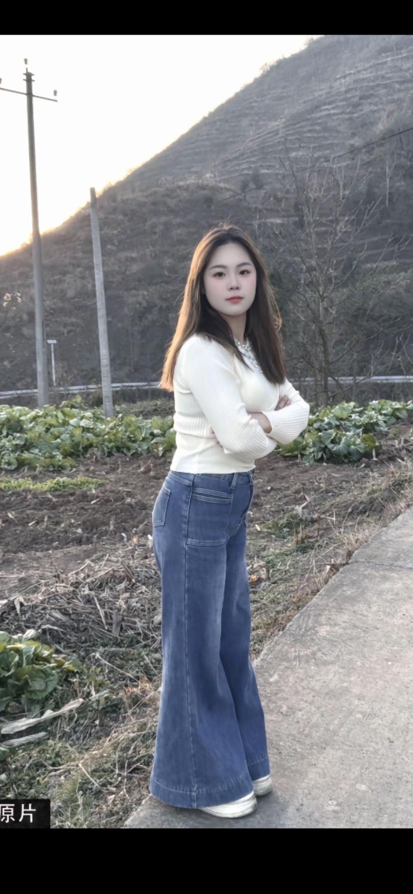 田野里的时尚少女，牛仔裤与白色毛衣的完美搭配，自然与时尚的完美融合。