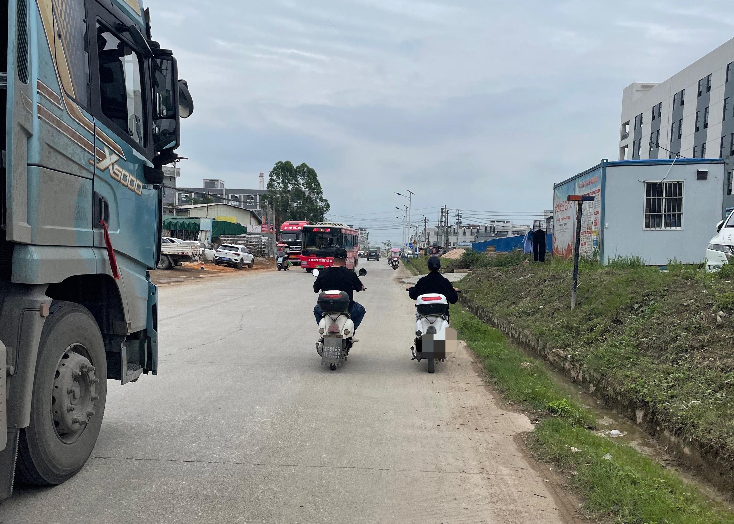 【玉林某工业园道路女子和男子并排骑车】5月4日，玉林市某工业园区道路上一名女子和