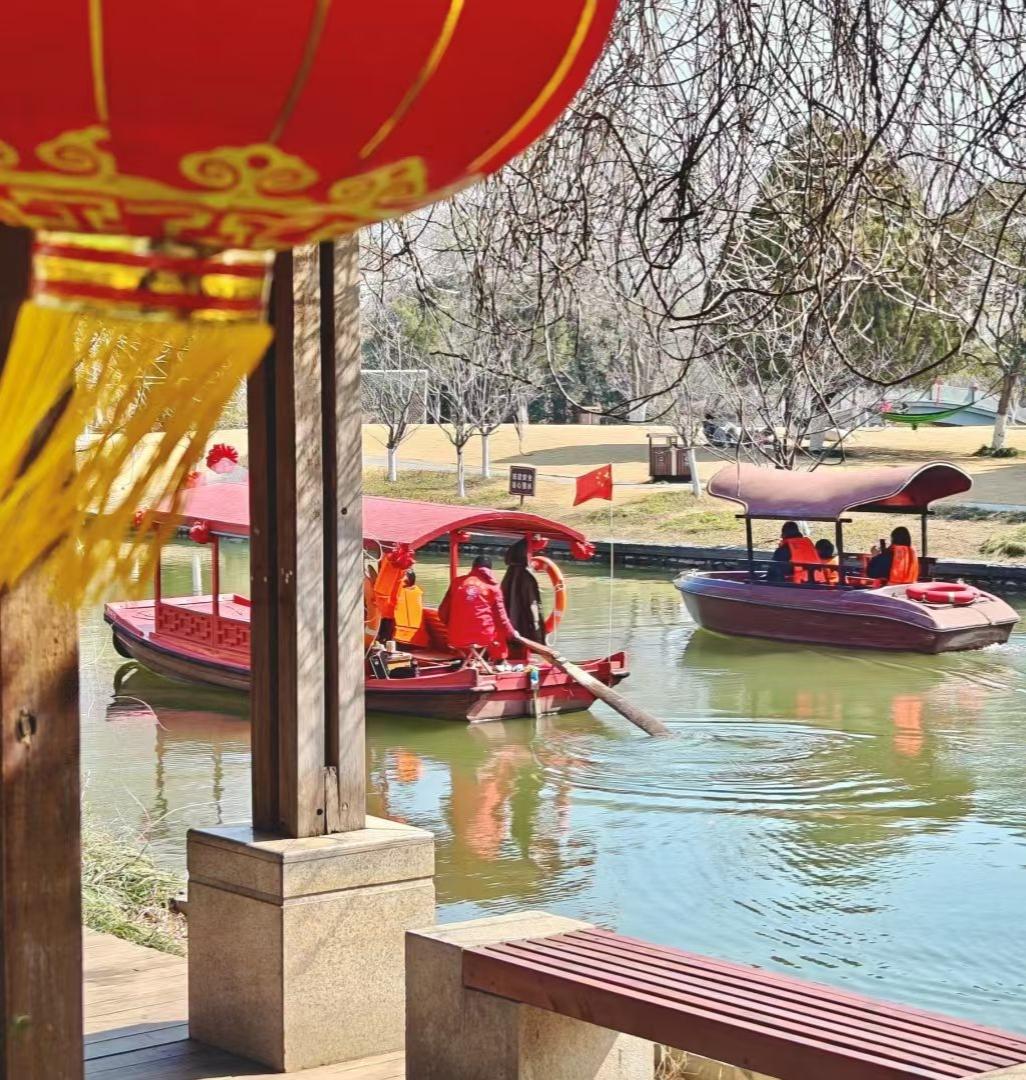 2. 檐下红灯映碧水，舟行波上载欢歌。不必追赶时间，就这样坐在暖阳里，看岁月流淌