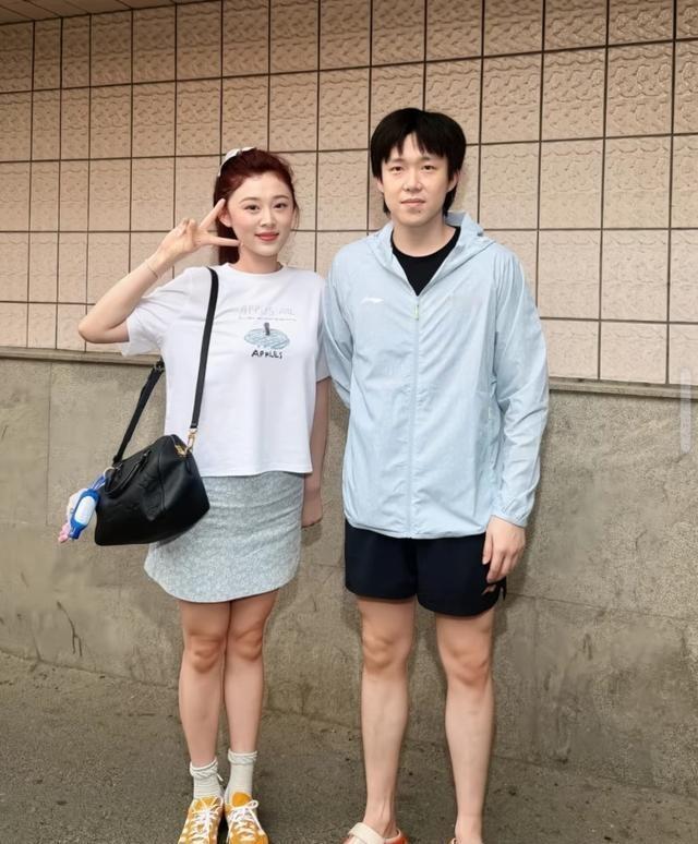 王楚钦与师母合影时，双手背在身后，身姿挺拔如松，透着几分拘谨与敬重；可当他牵起教