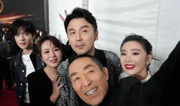 这张5人合照，我只认出了喜容绽放的著名导演张艺谋，清眸流盼的雷佳音，凤眉丰颊的马