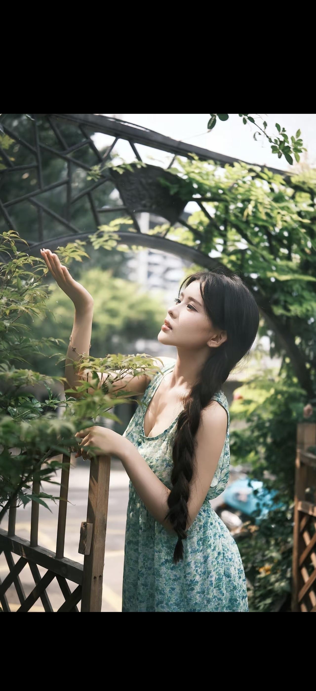 一个女孩在花园里闻花香。