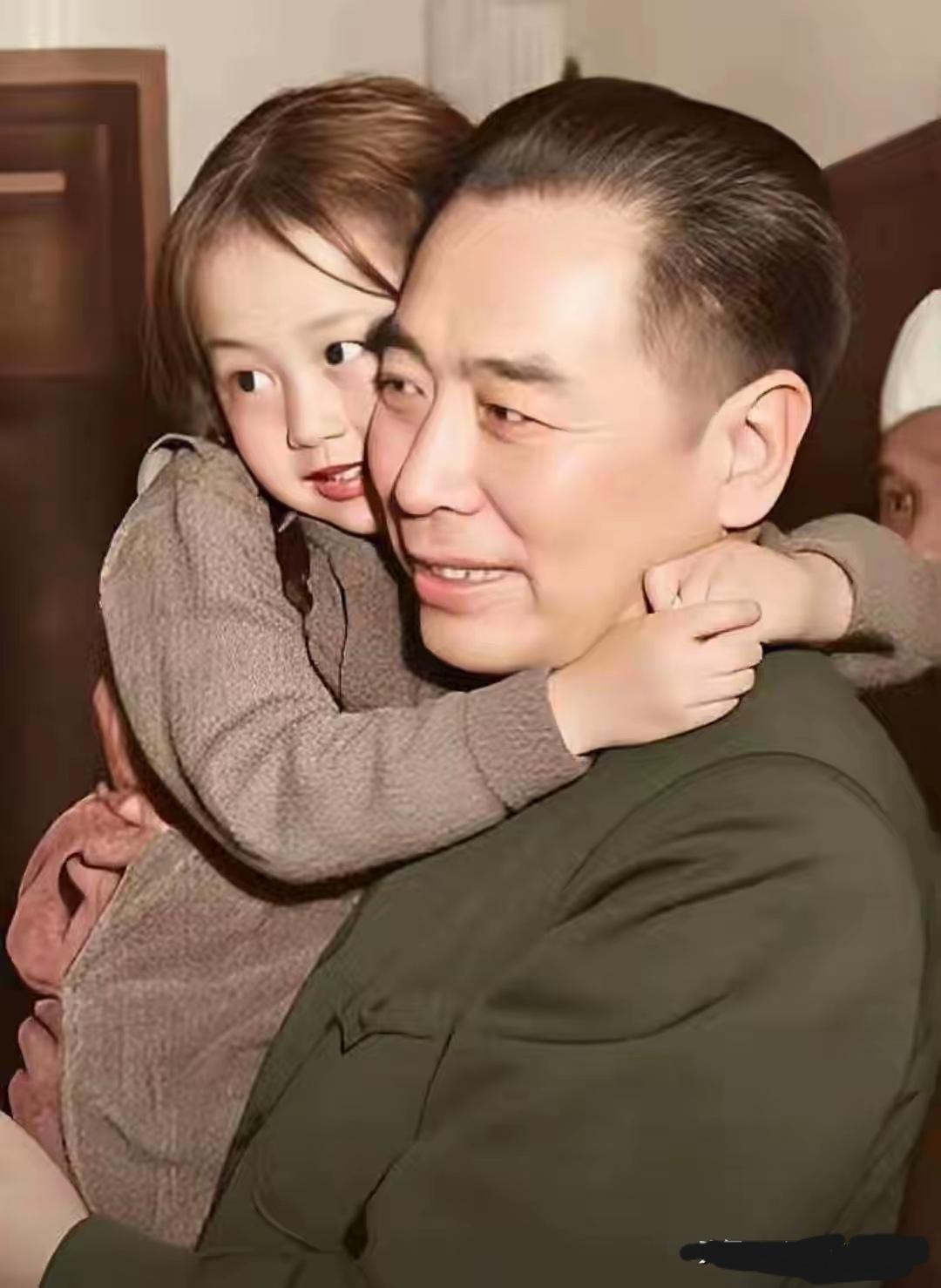 那时，周总理亲切地抱起一位革命烈士的小女孩，可爱的小女孩一把抱住周总理的脖子说：