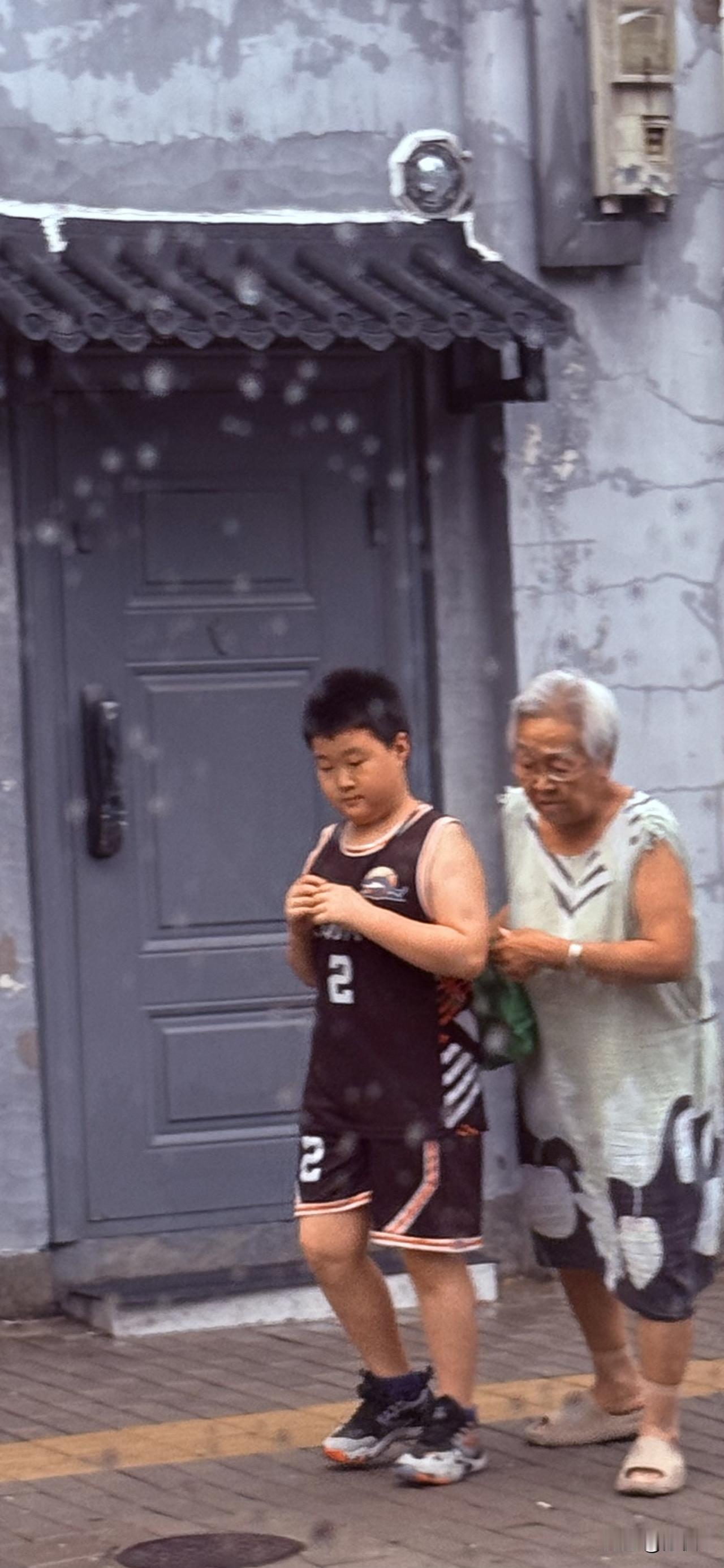 车窗外的祖孙情。北京胡同里小雨绵绵。奶奶带着大孙子回家，一个简单的动作就能看出来