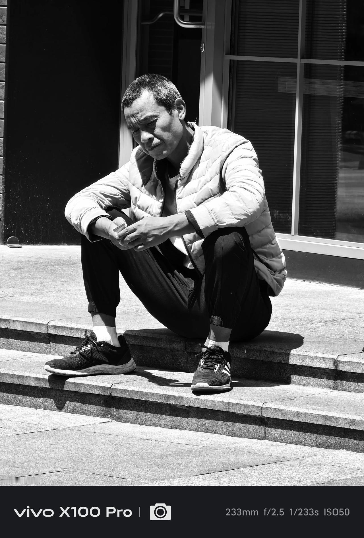 时光匆匆，岁月如梭。一位男子坐在台阶上，沉思着什么。他的神情深邃，仿佛在回忆过去