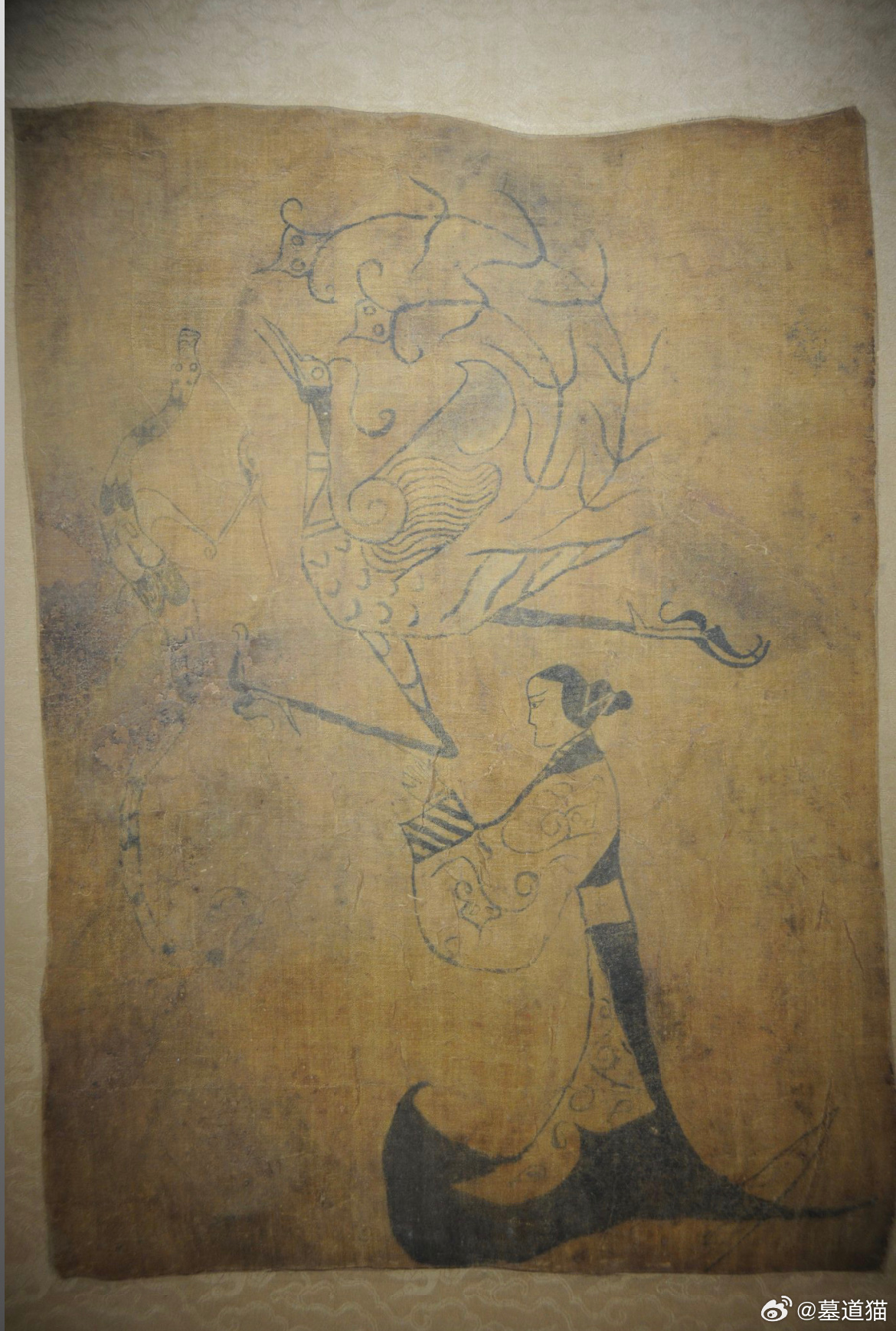 人物龙凤帛画，湖南博物馆/藏绘龙凤引导墓主人的灵魂升天的情景。画中右下方有一位侧