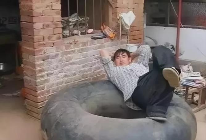 第一张，是成名前的大衣哥，落魄地躺在一个大轮胎上，身后是杂乱的房子，他因一天到晚