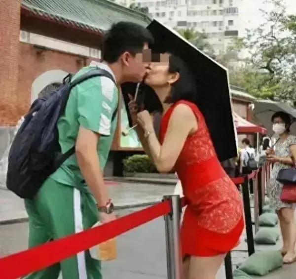 这一事件发生在广州越秀区的一个高考考场外。照片显示，一位母亲身穿红色连衣裙，在人