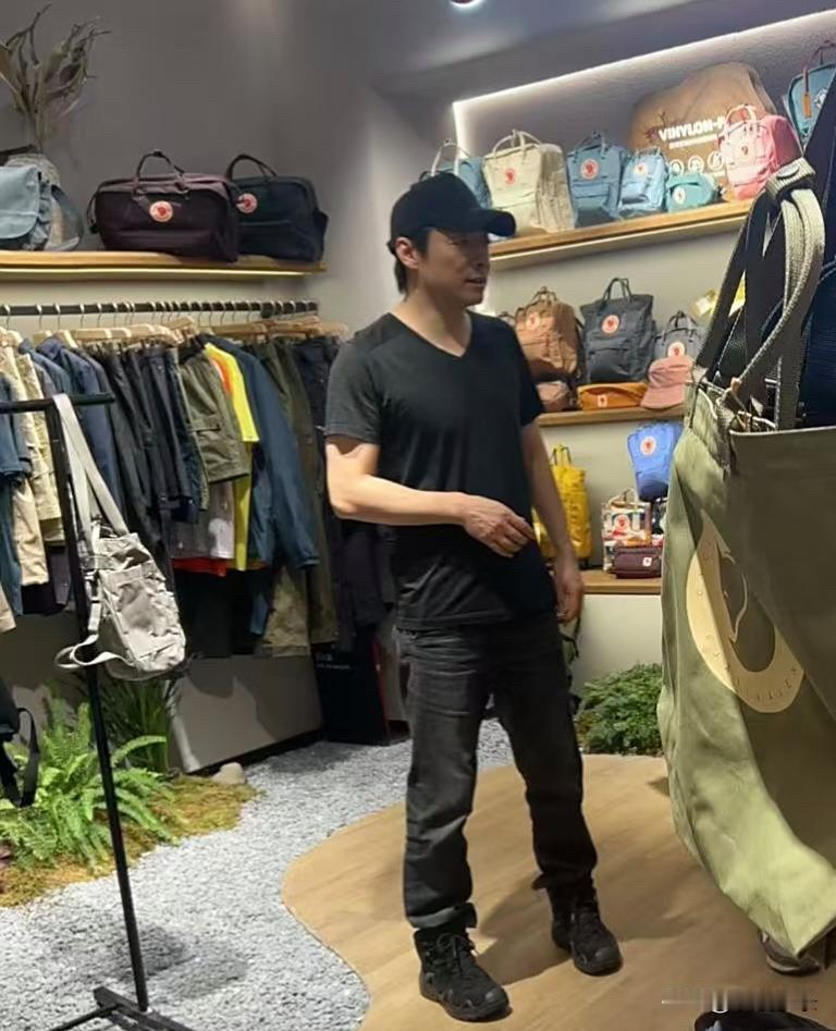 祖峰和老婆刘天池在北京三里屯逛街购物，他穿着一身黑衣，打扮有型，胸肌饱满，身高看
