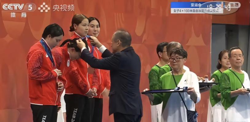 国内网友吵翻了！日本亚运会给运动员颁奖时，颁奖托盘端在银发老人手里
