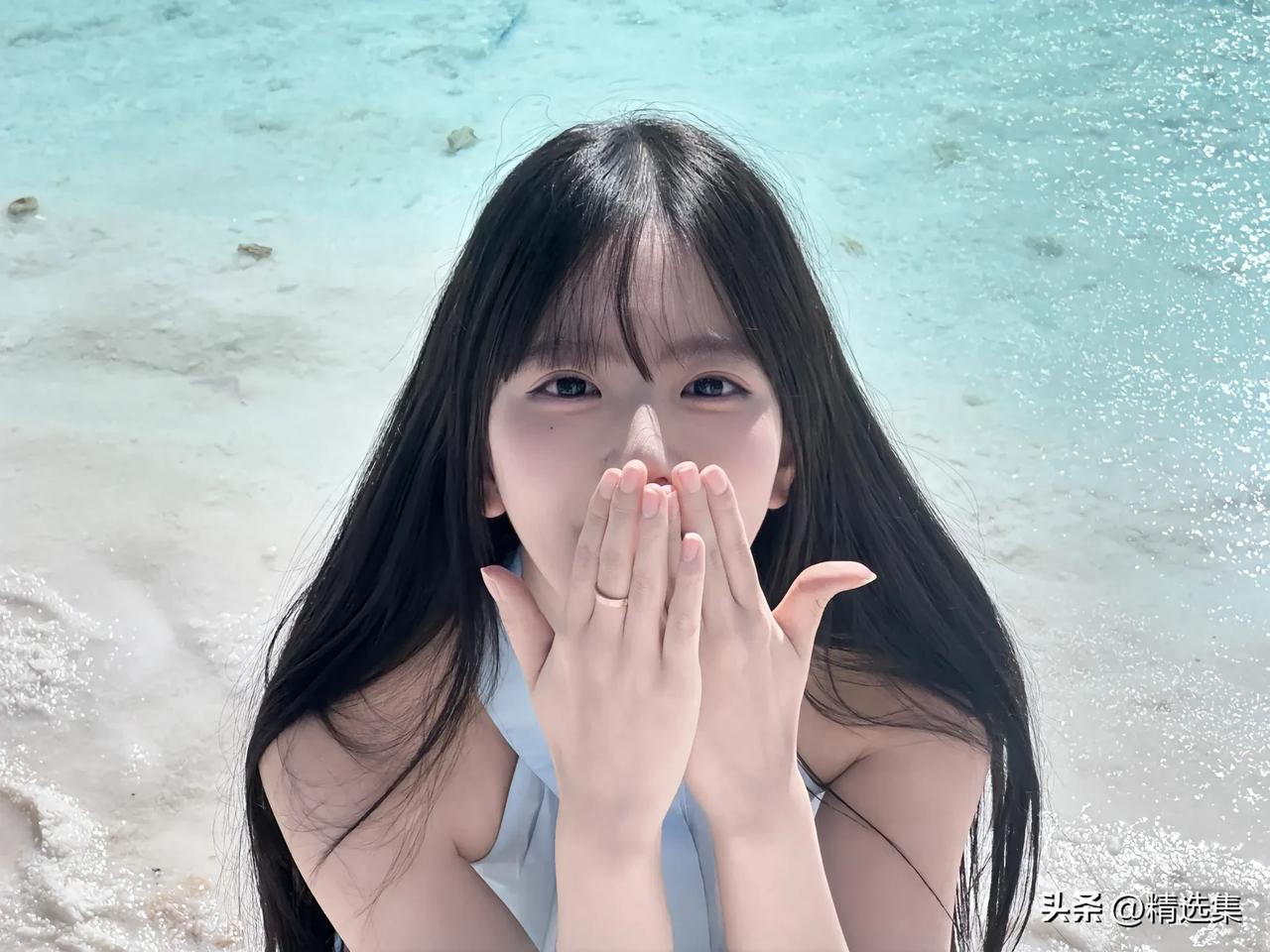 海边少女轻吻指尖，温柔的海风轻抚发梢