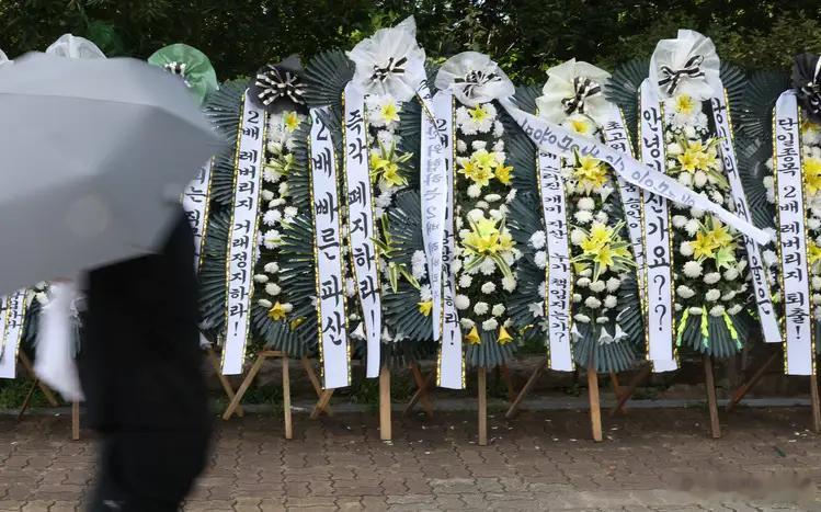 7月29日，韩国首尔国会大厦前，一长串白色“吊唁花圈”排列在人行道上，抗议三星电