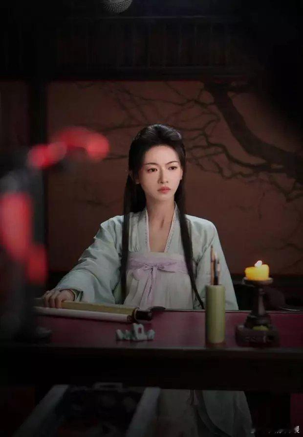 吴谨言身着浅绿色古装，专注看着手中物件，清丽素颜。 ​​​
