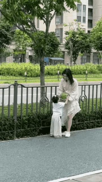 一位年轻妈妈和自己小不点的女儿，在回家的路上买了一个西瓜🍉，妈妈开始抱着西瓜?