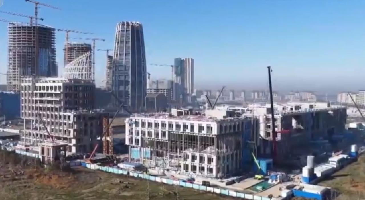 画面中既有现代化建筑群拔地而起，极具设计感的楼体在开阔的土地上勾勒出城市新轮廓；