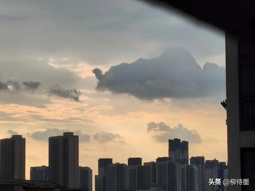 看，这张天空的照片，像什么？
前面的小片乌云，像驼队；后面这个大的，像准备开屏的