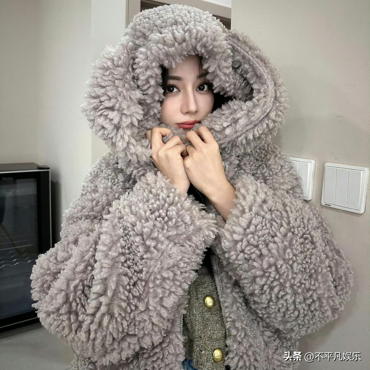 迪丽热巴的毛绒兔穿搭堪称春日甜美风范本！她以白色垂坠兔耳毛绒帽为核心单品，帽型蓬