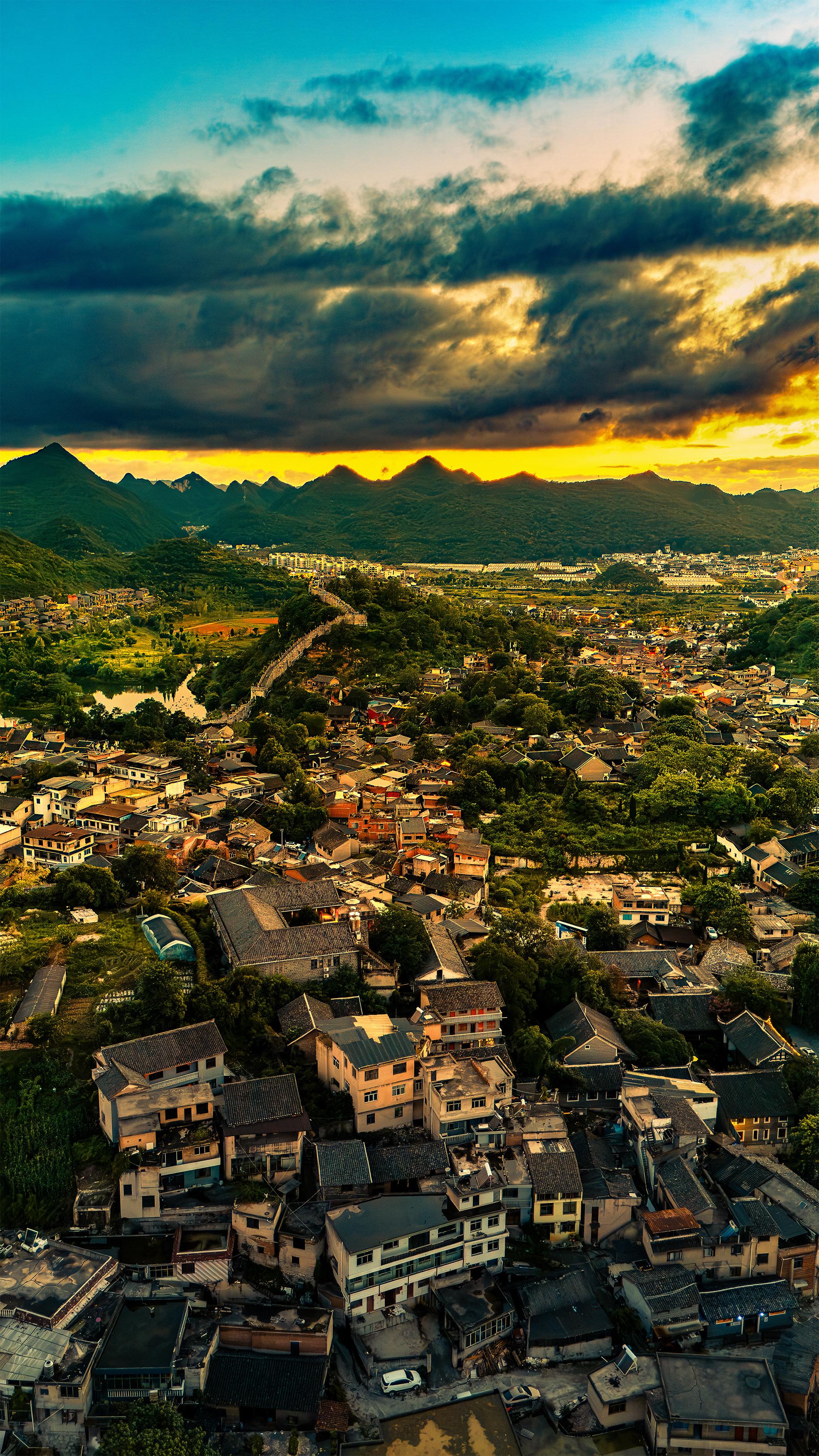 青岩古镇山与城的黄昏诗，云层裹着落日的金，古镇嵌在山的柔里，灰瓦叠着烟...